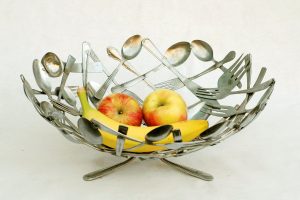 The Coluna Marble Fruit Bowl using spoons should be facing outward, curving slightly to form the bowl shape, while the forks can be positioned with their handles pointing inward.